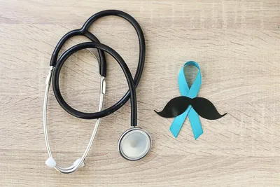 Estetoscopio junto a cinta azul y bigote simbolico representando conciencia sobre el cancer de prostata