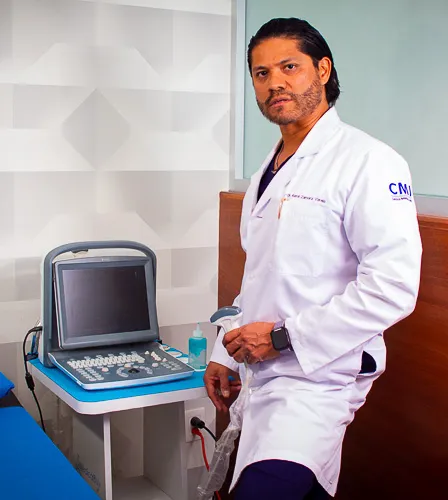 disfuncion_erectil_urologo_rene_zamora_queretaro_ultrasonido_diagnostico_448x500 Dr Rene Zamora con bata medica junto a ultrasonido en consultorio de Queretaro
